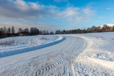 Orman woth mavi gökyüzü buz ve kar kaplı karlı kış yolu