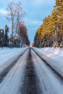 Orman woth mavi gökyüzü buz ve kar kaplı karlı kış yolu