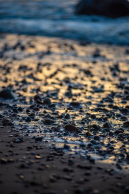 Letonya kayalık deniz kıyısı ile sahilde fırtına hava. yüksek dalgalar ile kayalar üzerinde günbatımı