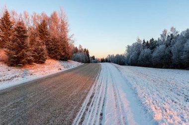 Orman woth mavi gökyüzü buz ve kar kaplı karlı kış yolu