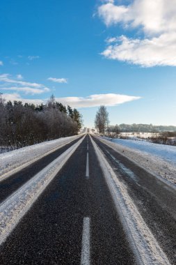 Orman woth mavi gökyüzü buz ve kar kaplı karlı kış yolu