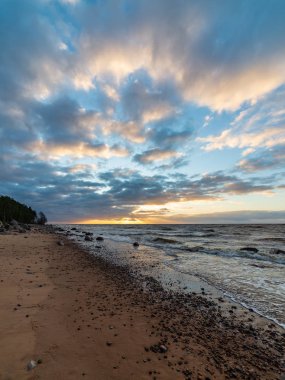 Letonya kayalık deniz kıyısı ile sahilde fırtına hava. yüksek dalgalar ile kayalar üzerinde günbatımı