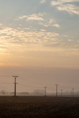 sonbaharda Slovakça manzara üzerinde bulutlu ve sisli gündoğumu. Tatra güneş doğar gibi arka planda moountains. Elektrik direkleri alanında