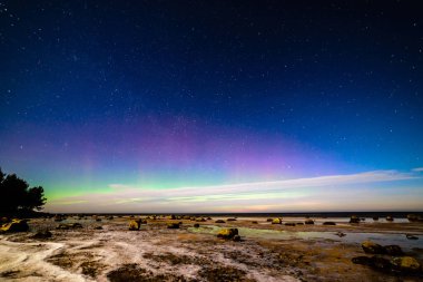 Kış aylarında deniz Plajı üzerinde karanlık gece Aurora Borealis ve yıldızlar. Kuzey ışıkları