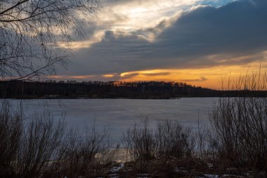 nehirde sakin su ile ormanda kışın turuncu kırmızı gün batımı