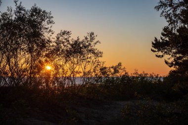 kırık bulutlar ile akşam deniz üzerinde koyu kırmızı günbatımı