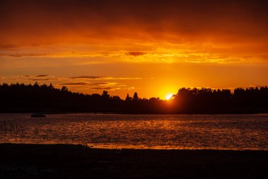 kırık bulutlar ile akşam deniz üzerinde koyu kırmızı günbatımı