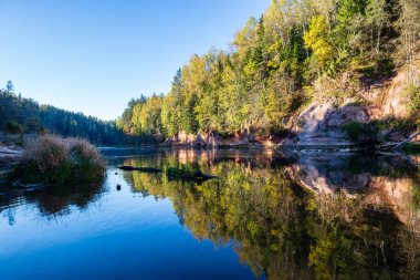 kıyılarda kumtaşı kayalıklar ile orman nehri üzerinde güzel altın gündoğumu. fırtınalı su