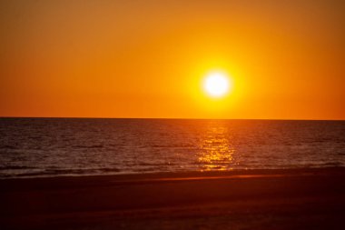 kırık bulutlar ile akşam deniz üzerinde koyu kırmızı günbatımı