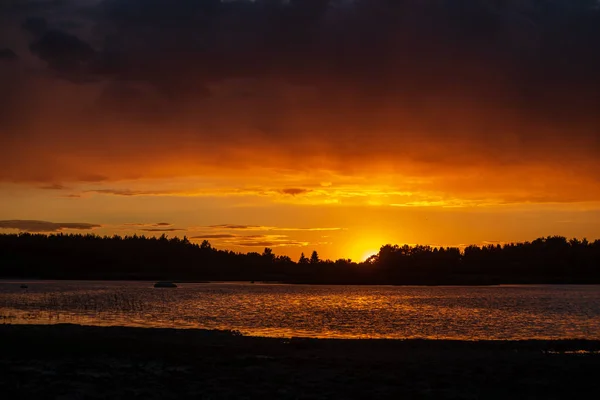 dark red sunset over sea in evening with broken clouds