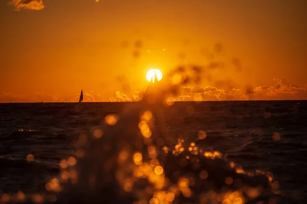 dark red sunset over sea in evening with broken clouds