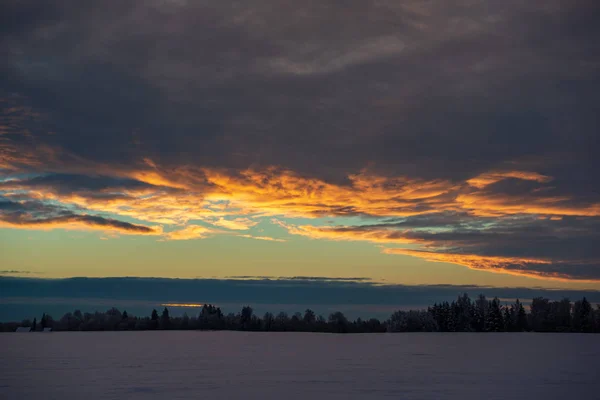 田舎の冬の雪のフィールド上のカラフルな夕日の光 — ストック写真