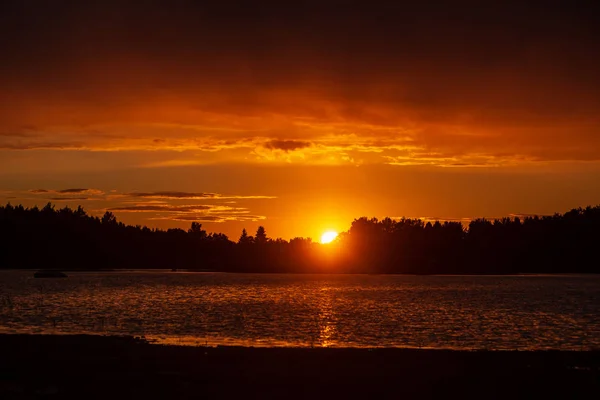 dark red sunset over sea in evening with broken clouds