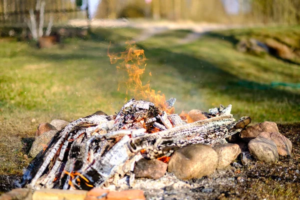 Ανοιχτά ξύλα για την καύση της φωτιάς στο χωράφι με πράσινο γρασίδι — Φωτογραφία Αρχείου