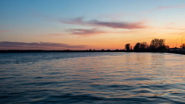 Colorido atardecer sobre el lago de mar con nubes de color rojo oscuro — Foto de Stock