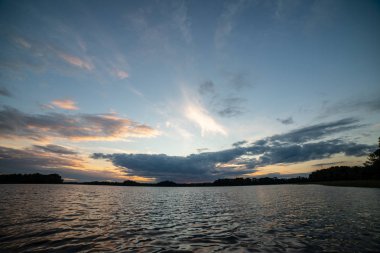 koyu kırmızı bulutlar ile deniz gölü üzerinde renkli gün batımı