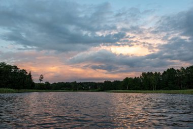 koyu kırmızı bulutlar ile deniz gölü üzerinde renkli gün batımı
