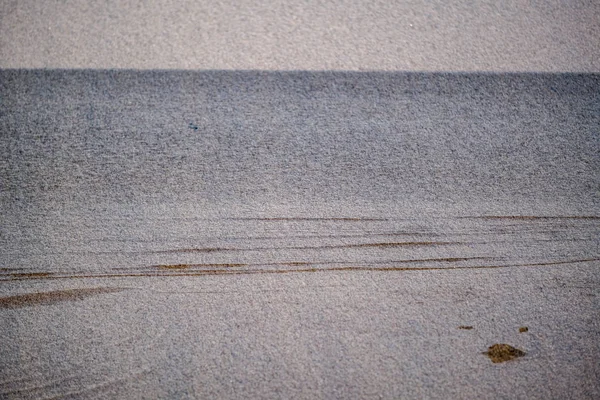 Пляж с песком и водой в солнечный день — стоковое фото