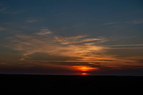 Pôr do sol colorido sobre o lago do mar com nuvens vermelhas escuras — Fotografia de Stock