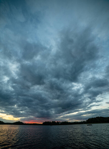 красочный закат над морским озером с темно-красными облаками
