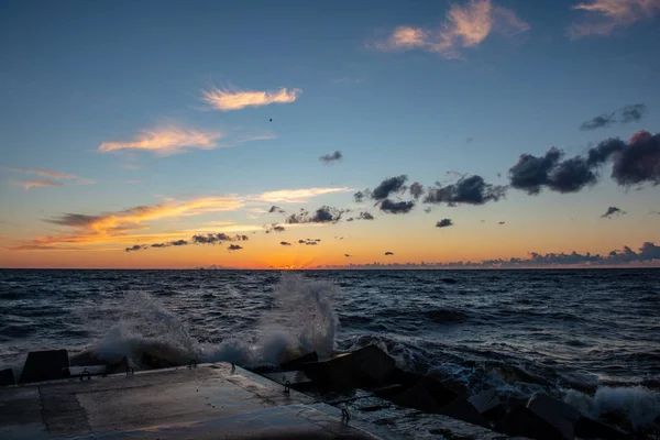 Barevný západ slunce nad mořským jezerem s tmavě červenými mraky — Stock fotografie
