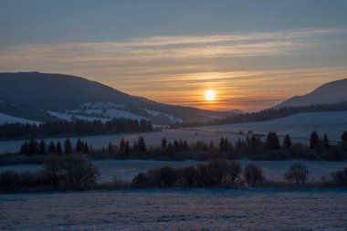 önünde karla kaplı alanları ile dağlarda kışın güzel gündoğumu