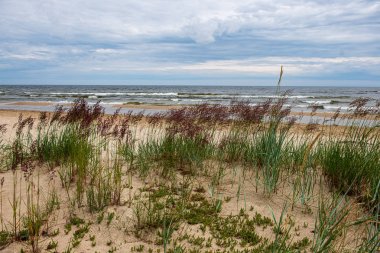 dalgalar ve kırık bulutlar ile yaz aylarında boş deniz plajı