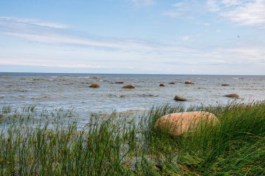 dalgalar ve kırık bulutlar ile yaz aylarında boş deniz plajı
