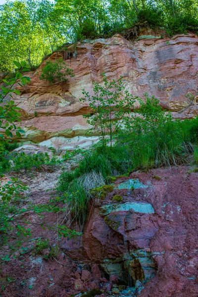 Natural sand stone cliffs on the shore of the river in forest — Stock Photo, Image