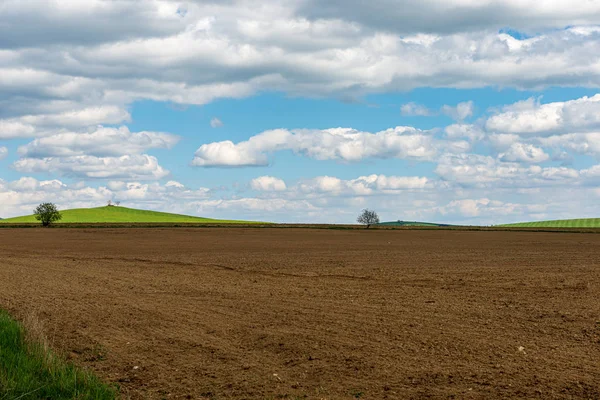 Cultivated fields in countryside with dark and wet soil for agri — Stock Photo, Image