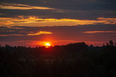 ağaçlar ve alanlar üzerinde gökyüzünde dramatik kırmızı günbatımı renkleri