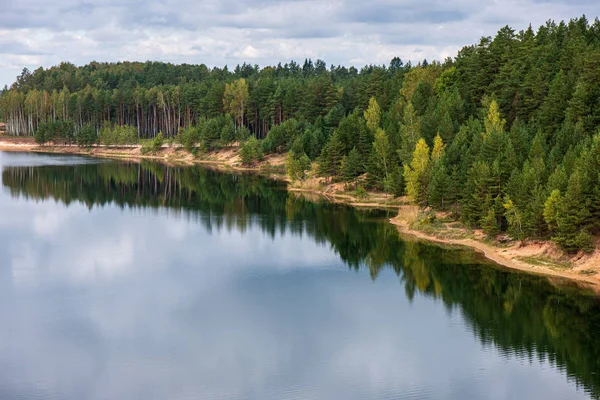 Calme campagne lac rivière avec des reflets nuageux dans l'eau et — Photo