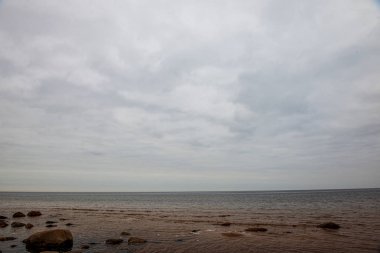 beyaz kum, büyük kayalar ve eski ahşap ile yalnız boş deniz Plajı