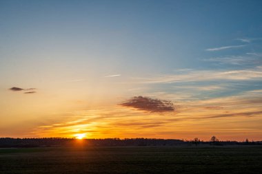 ağaçlar ve alanlar üzerinde gökyüzünde dramatik kırmızı günbatımı renkleri