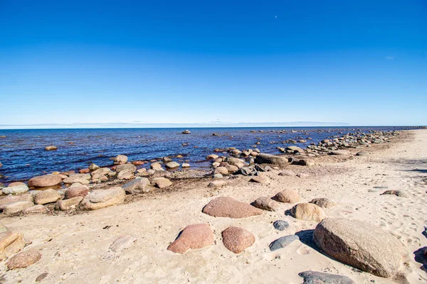Solitaria playa de mar vacío con arena blanca, grandes rocas y madera vieja —  Fotos de Stock