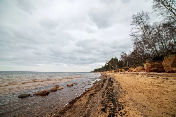 Plage solitaire mer vide avec sable blanc, de grands rochers et vieux bois — Photo