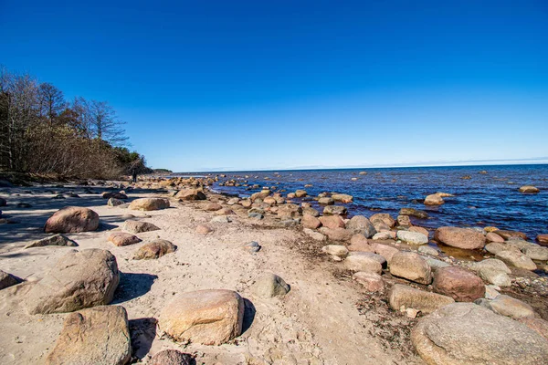 beyaz kum, büyük kayalar ve eski ahşap ile yalnız boş deniz Plajı