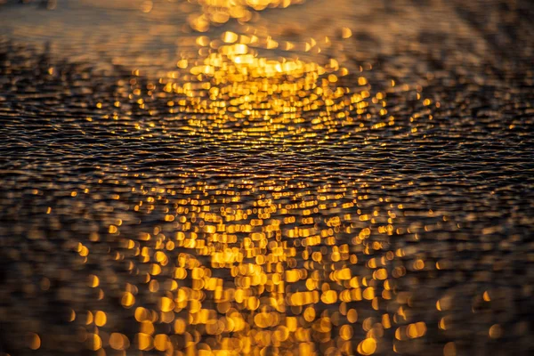 Luz do pôr do sol reflexão na praia areia molhada e água — Fotografia de Stock