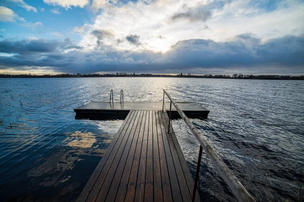 Klar himmel med dramatiska moln över sjön i solnedgången — Stockfoto