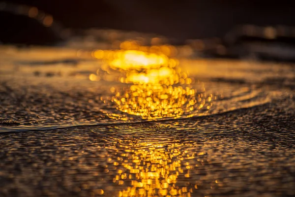 Luz do pôr do sol reflexão na praia areia molhada e água — Fotografia de Stock