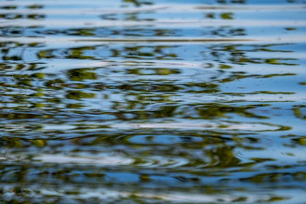 Textura de água com reflexos e rochas no fundo do riacho — Fotografia de Stock