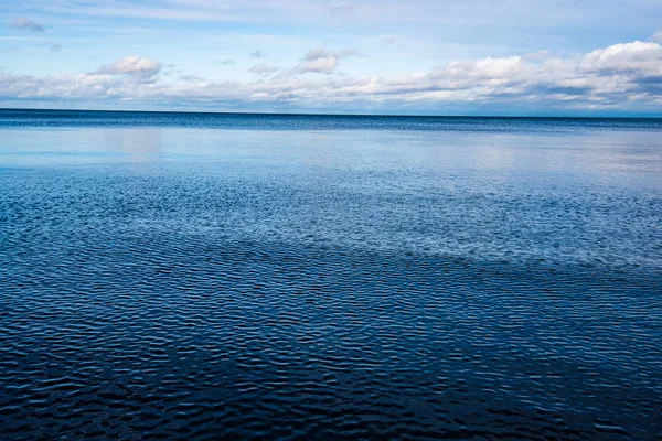 Beyaz kum ve mavi suyla rüzgarlı deniz plajı — Stok fotoğraf