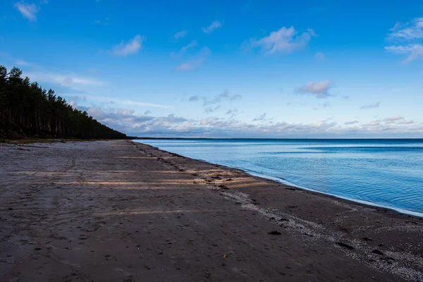 Winderig zeestrand met wit zand en blauw water — Stockfoto