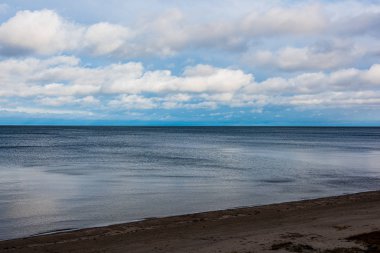 Beyaz kum ve mavi suyla rüzgarlı deniz plajı