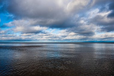 Beyaz kum ve mavi suyla rüzgarlı deniz plajı