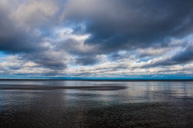 Beyaz kum ve mavi suyla rüzgarlı deniz plajı