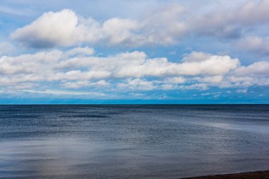 Beyaz kum ve mavi suyla rüzgarlı deniz plajı