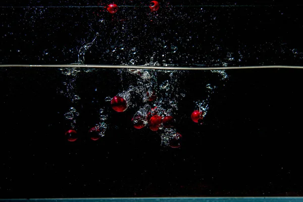 Arándanos que caen en agua oscura con salpicaduras — Foto de Stock