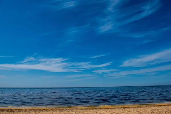 Wietrzna plaża morska z białym piaskiem i błękitną wodą — Zdjęcie stockowe