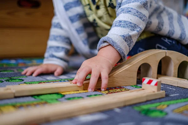 Bir ca ahşap raylar üzerinde ahşap tren seti ile oynayan bebek elleri — Stok fotoğraf